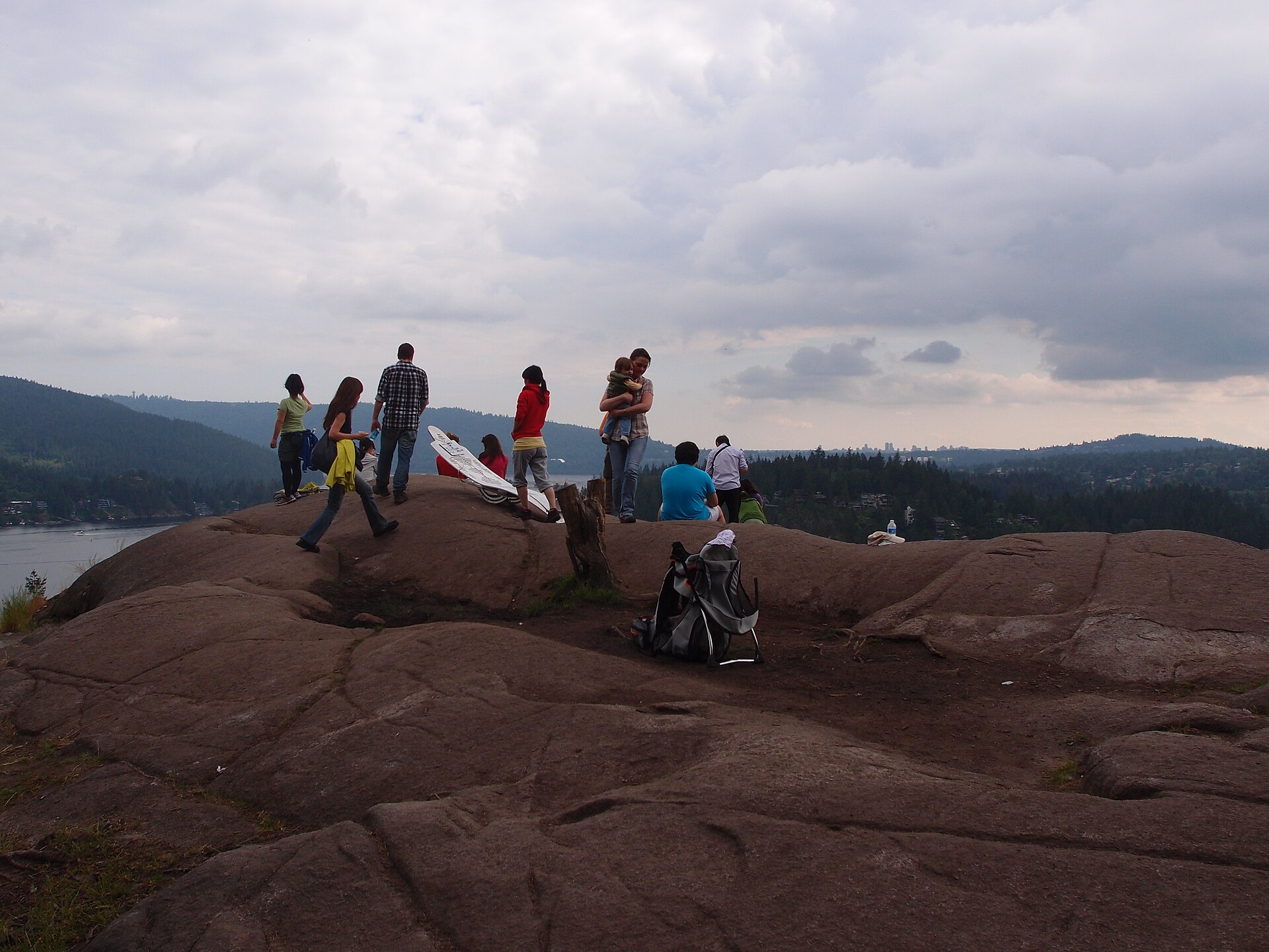Hikers on the bare summit rocks of Quarry Rock above Deep Cove